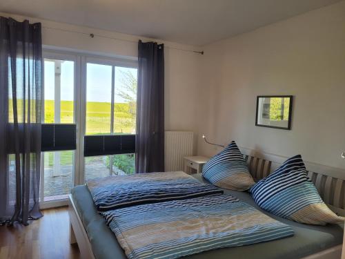 北滩岛Ferienhaus Wattenmeerblick的卧室内的一张床铺,设有大窗户