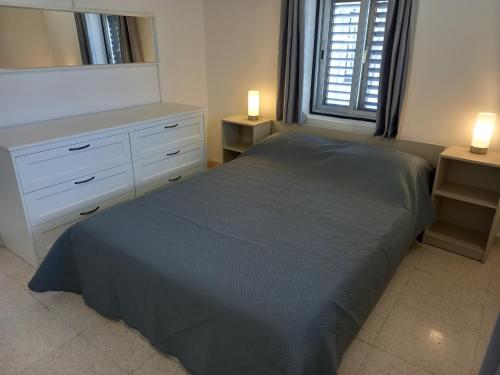 KornosAchilles Heel的一间卧室配有一张床、一个梳妆台和一扇窗户。