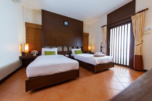 北碧凯维河大桥度假村的酒店客房设有两张床和大窗户。