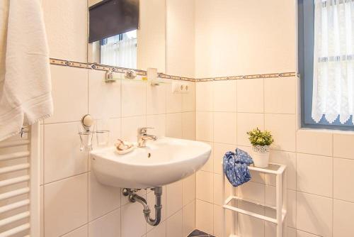 PutgartenFerienwohnungen in der Ferienanlage Kap Arkona的白色瓷砖浴室内的白色水槽