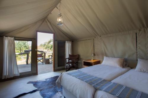 侯斯普瑞特MILIMA Big 5 Safari Lodge的一间帐篷内带两张床的卧室