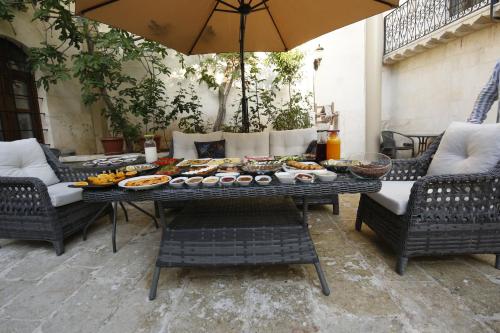 尚勒乌尔法Kaliruha Boutique Hotel的一张桌子,上面有食物,还有椅子和雨伞