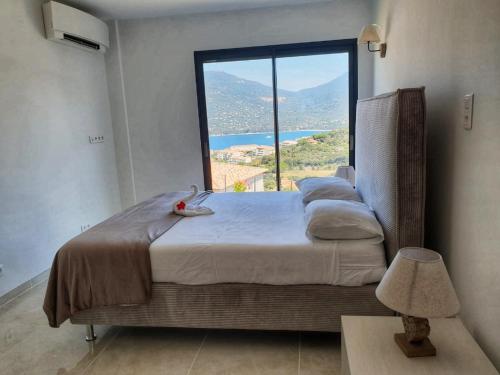 普罗普里亚诺Appartement neuf 3 chambres vue mer Propriano的一间卧室设有一张大床和大窗户