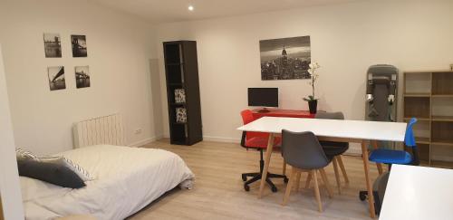 马赛Adorable studio 25m² très calme avec parking的一间卧室配有一张床、一张桌子、一张床和一张桌子