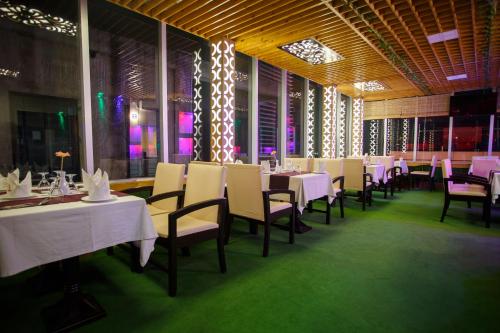 达卡HOTEL BLUE BIRD的一间设有白色桌椅的用餐室