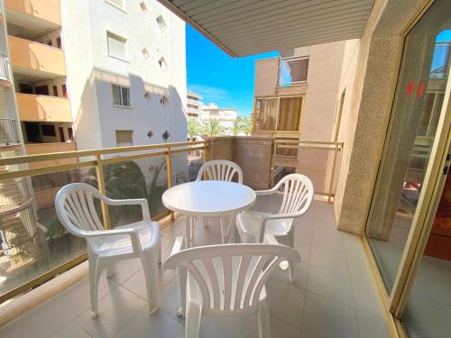 萨洛Apartamentos Amatista的阳台上配有白色的桌椅