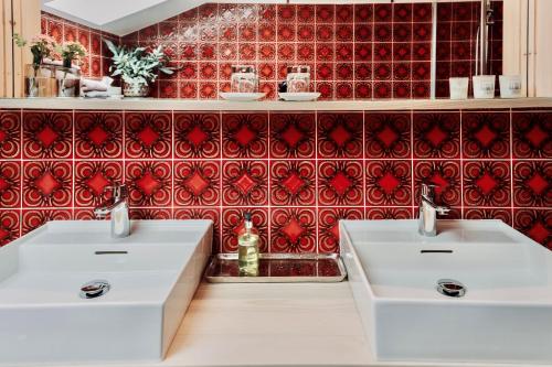 基姆湖畔布赖特布伦Ferienwohnung ChiemseeAlpenBlick的浴室设有两个白色水槽,铺有红色瓷砖。