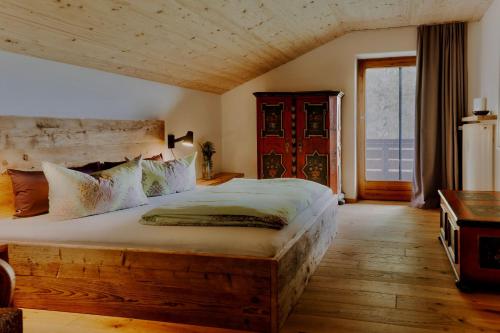 基姆湖畔布赖特布伦Ferienwohnung ChiemseeAlpenBlick的一间卧室设有一张大床和一个大窗户