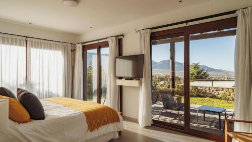 塔菲德尔瓦勒La Madrina Apart Hotel的一间卧室设有一张床和一个滑动玻璃门