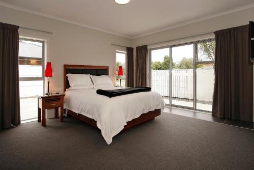 北帕默斯顿城市企业汽车旅馆的一间卧室设有一张大床和窗户。