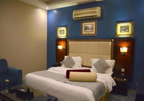 吉达Tobal Al Hamra Hotel Apartments的一间卧室设有一张蓝色墙壁的大床
