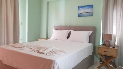 瓦西利基Bayside Apartments的卧室配有白色的床和2条毛巾