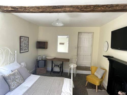凯尔苏斯Y Felin Bed and Breakfast and Smallholding的一间卧室配有一张床、一张书桌和一台电视