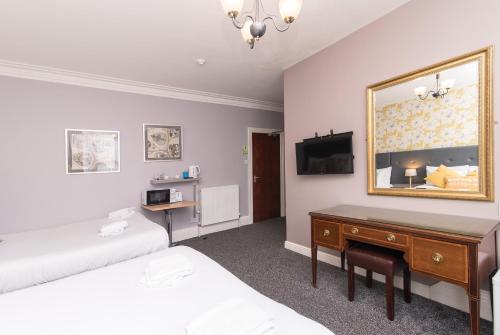 诺丁汉The Linden Leaf Rooms - Classy & Stylish的一间卧室配有一张床、一张书桌和一面镜子