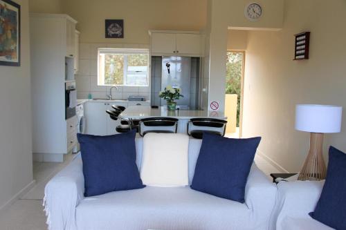 普利登堡湾W8 - Goose Valley Golf Estate的厨房里配有带蓝色枕头的白色沙发
