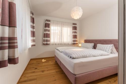 拉姆绍达赫斯坦Appartement Alpengefühl am Dachstein的一间卧室设有一张床和一个大窗户