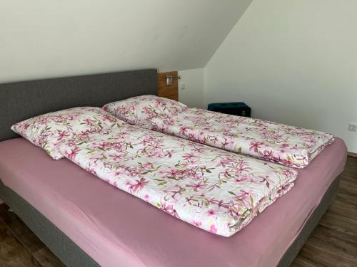 东贝沃恩Gästezimmer Am Haarhaus的床上有粉红色毯子