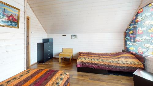 拉彭兰塔Saimaa Marina Garden Apartments的阁楼卧室配有两张床和椅子