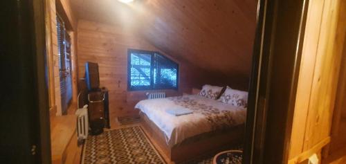 巴亚马雷Cabana Ignis的木制客房内的一间卧室,配有一张床
