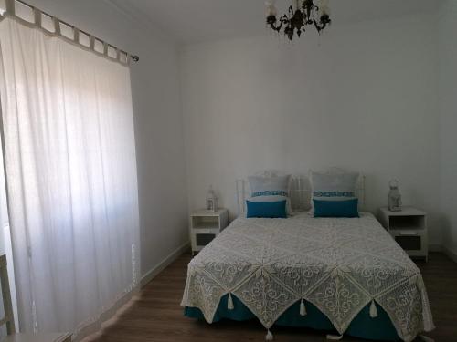 蒙塔吉尔Alojamento Justo - vila de Montargil的一间卧室配有一张带蓝色枕头的床