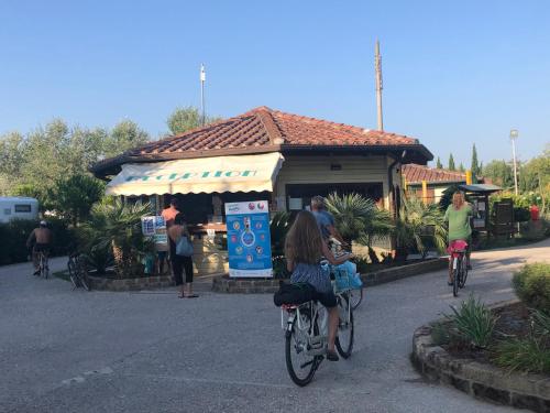 维亚雷焦Toskana, Viareggio,Chalet 27 mit Klimaanlage und Wlan的一群人在车前骑车