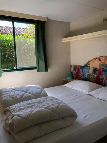 维亚雷焦Toskana, Viareggio,Chalet 27 mit Klimaanlage und Wlan的一间卧室设有两张床和窗户。