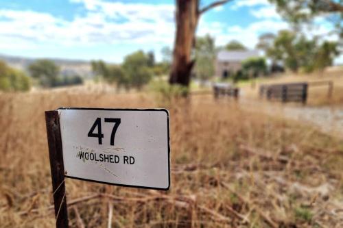 Mount Torrens47 WOOLSHED ROAD - Adelaide Hills rural retreat的田野前的柱子上的标志