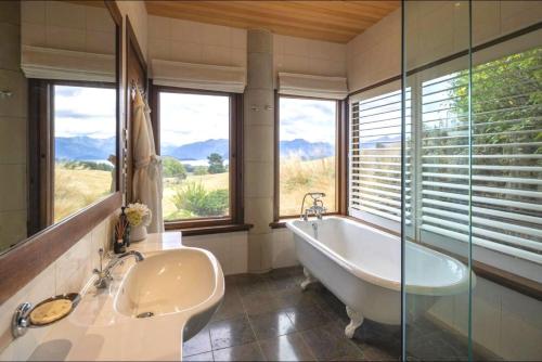 马纳普里Cabot Lodge - Fiordland National Park的带浴缸、水槽和窗户的浴室