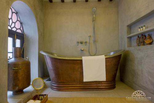 加尔各答Calcutta Bungalow的带淋浴的浴室设有大型木制浴缸