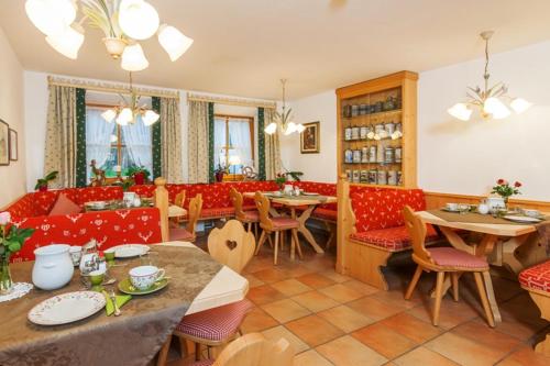 雷特温克尔Gästehaus beim Foidlmoar Familie Höflinger的一间带桌子和红色椅子及桌子的餐厅