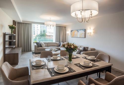 内罗毕Yaya Hotel & Apartments的客厅配有桌椅和沙发