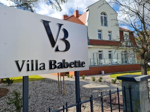 斯维诺乌伊希切Villa Babette - Ubernachtung, Parkplatz, Kurtaxe, Wifi, Aufraumung - Alles im Preis!的一座别墅楼前的标志