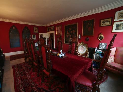 格拉斯顿伯里The Covenstead的红色的用餐室配有桌椅
