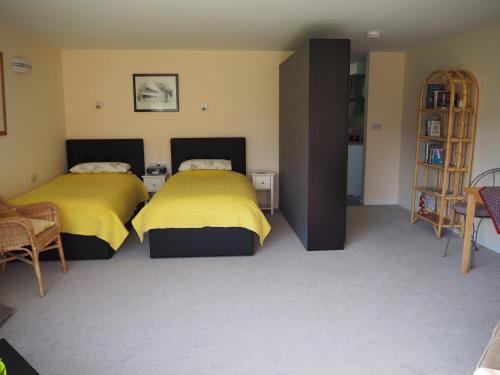 特鲁罗Truro apartment in a stunning quiet location的配有黄色床单的客房内的两张床