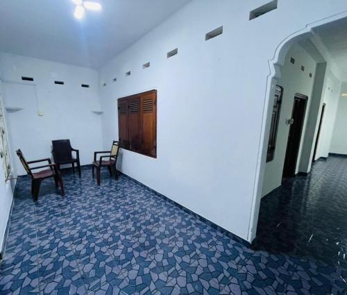 贾夫纳Jaffna RR Holiday Home Non AC的走廊设有两把椅子和木门