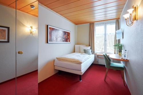 图芬Hotel & Spezialitätenrestaurant zur Linde的一间卧室配有一张床、一张书桌和一个窗户。