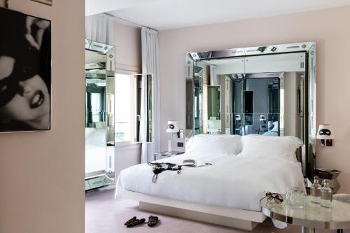 威尼斯Palazzina Grassi的卧室配有白色的床和大镜子