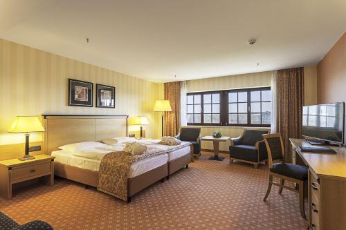 德累斯顿玛丽蒂姆德累斯顿酒店的配有一张床和一张书桌的酒店客房