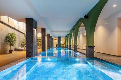 罗希姆诺Minos Ambassador Suites & Spa - Adults only的一座建筑物中央的游泳池