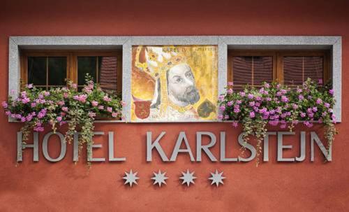 卡尔施泰因Hotel Karlštejn & SPA的酒店厨房的标志,有两个窗户和鲜花