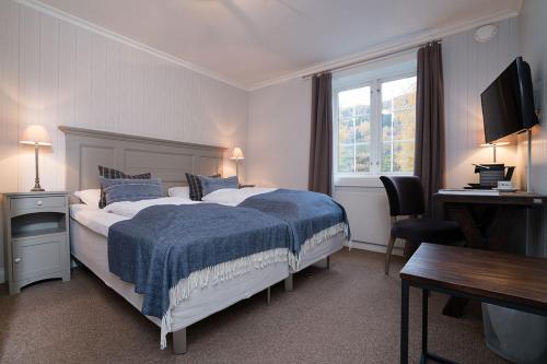 哈山历史酒店的一间卧室配有一张带蓝色毯子的大床