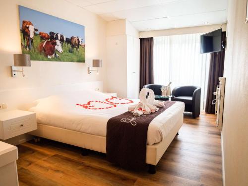 斯莱纳肯斯莱纳肯贝斯特韦斯特酒店的酒店客房,配有一张床和一幅牛油画