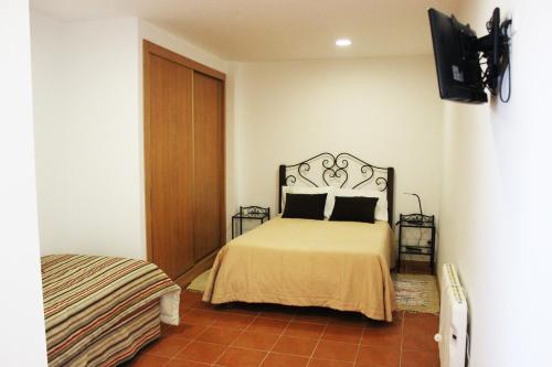 Sendim库拉尔皮诺酒店的一间卧室配有一张床,墙上配有电视