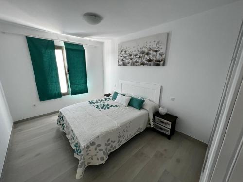 阿雷西费Arrecife exclusive beach house的一间白色卧室,配有床和2个窗户