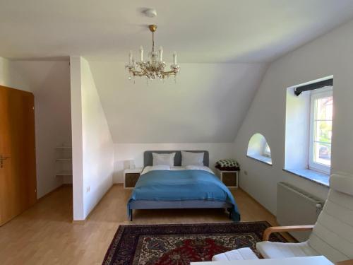 沃尔夫斯堡Schlossapartments Wolfsberg的一间卧室配有蓝色的床和吊灯。