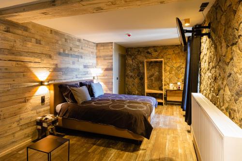 杜柏Le Lignely的一间卧室设有石墙和一张床