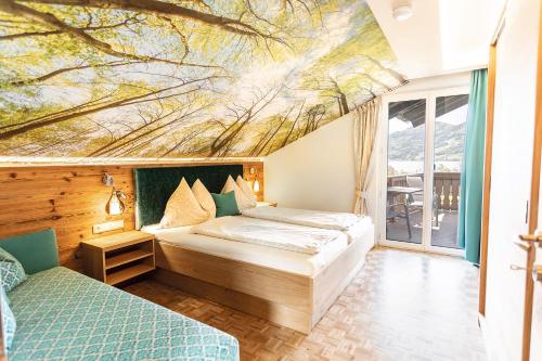 阿特湖畔施泰因巴赫巴德尔公寓的一间卧室设有两张床,天花板上绘有绘画作品