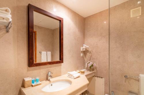 阿尔布费拉Hotel da Aldeia - Adults Only的浴室配有盥洗盆和带镜子的淋浴
