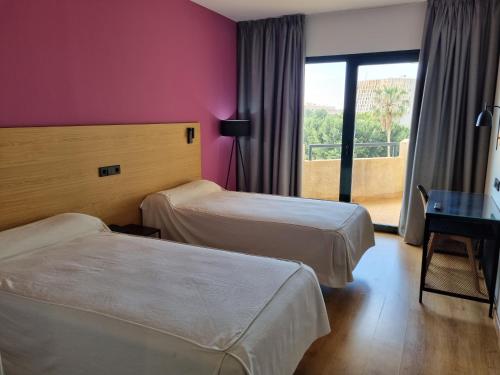 厄尔埃基多埃希多酒店的酒店客房设有两张床和窗户。