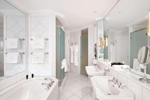 苏黎世巴尔拉克酒店的白色的浴室设有2个水槽、浴缸和卫生间。